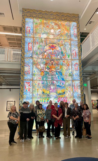 Members of the Emeriti and Retirees' Association posing for a group photo in front of the Aztec Goddess Mural during the Interpretive Walks Tour of the Cheech Museum in Riverside, California. 